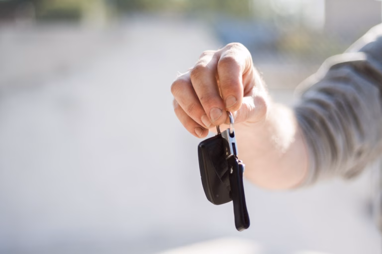 man holding out a car key